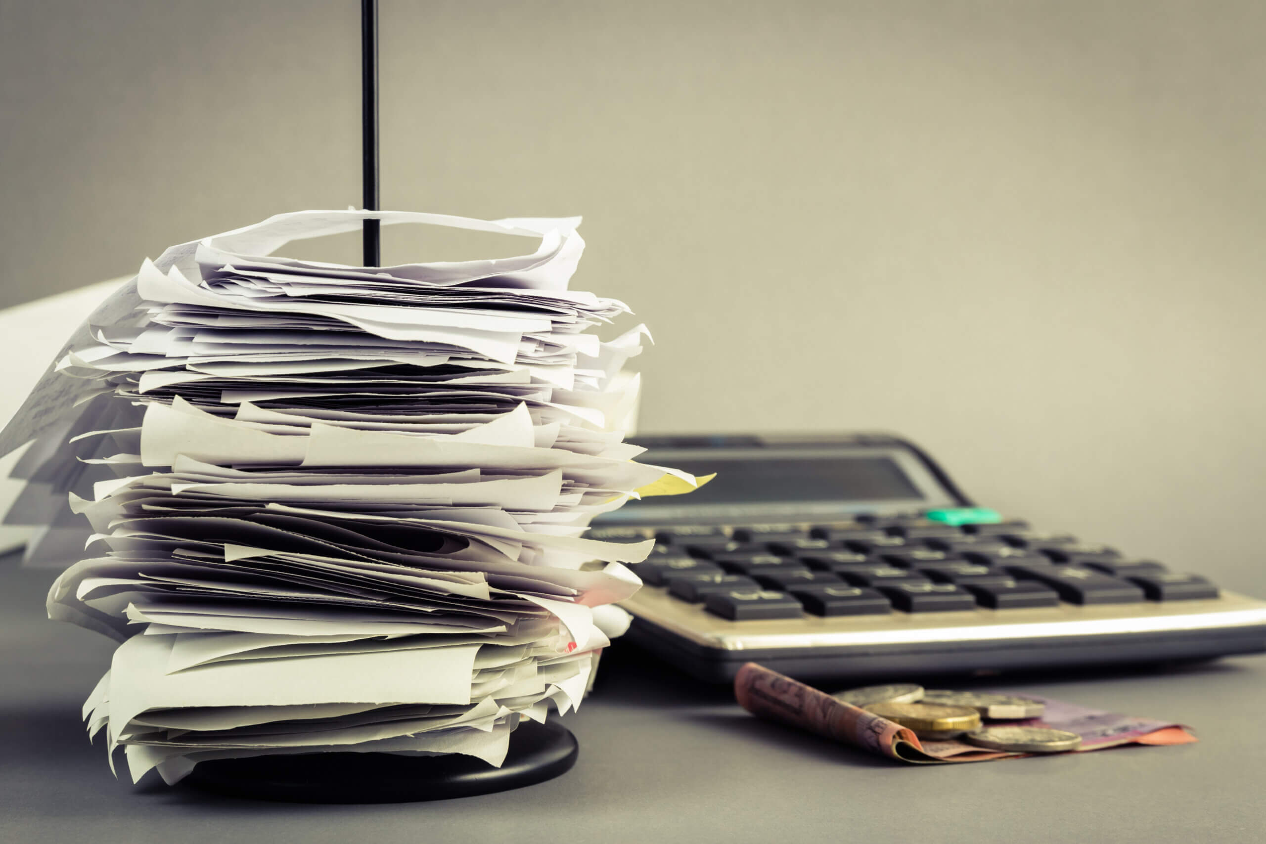 A stack of papers with a calculator next to it.